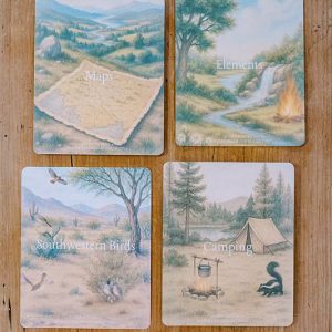 Image of four cards laying on a wooden table.