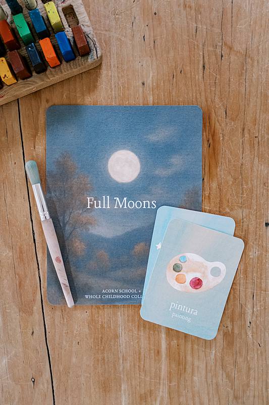 Cards on a wooden table with a paint brush laying on them