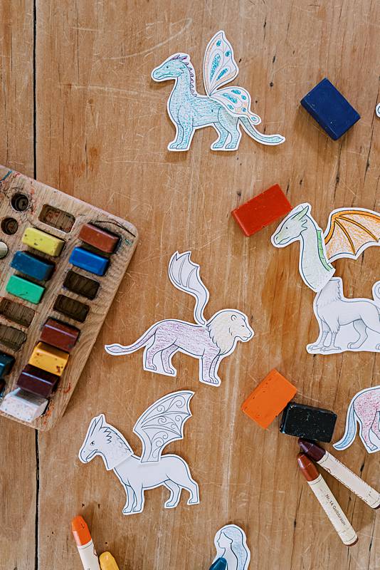 Cut out dragon toys laying on a wooden table