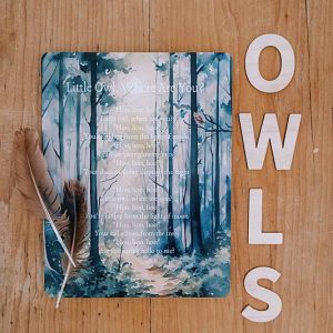 A card with wooden letters and feathers on a table